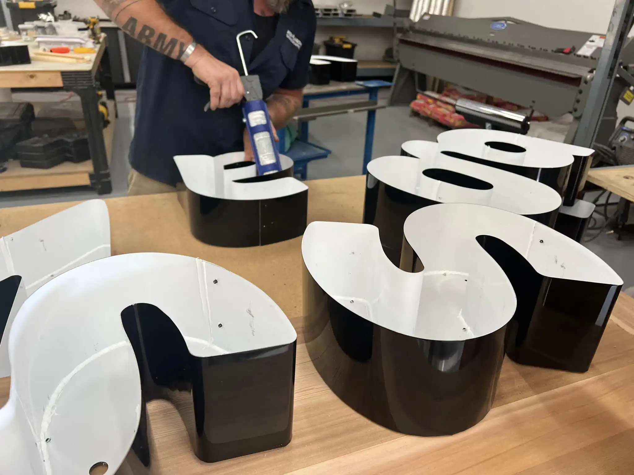 A man assembling illuminated channel letters.
