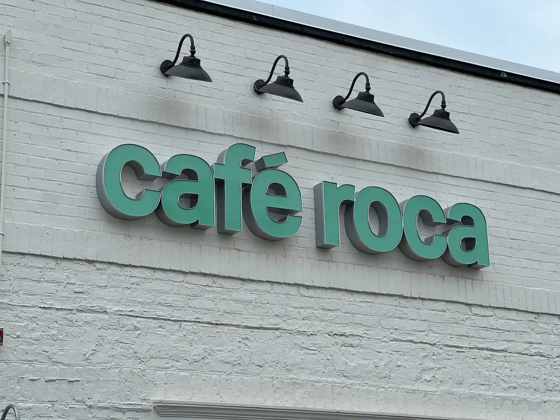 Minty Green Dimensional Channel Letter Sign on White Brick Building